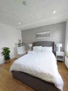 um quarto branco com uma cama grande e lençóis brancos em Elegant 2 bedroom Flat in Dartford - Kent em Dartford
