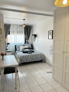 a bedroom with a bed and a table at Studio cosy avec vidéoprojecteur, à 100m du métro in Saint-Ouen