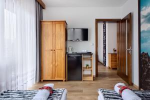 a living room with two beds and a kitchen at DW Na Równi Białka Tatrzańska in Białka Tatrzanska