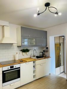 a kitchen with white cabinets and a sink at Apartament 88 - Mrągowo Centrum, 2 sypialnie, taras in Mrągowo