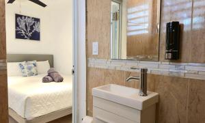 ein Badezimmer mit Waschbecken, Bett und Spiegel in der Unterkunft Oscar Building - Apto#1 in San Juan + 22 Fotos