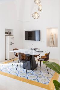 a dining room with a table and chairs on a rug at La Perle Ostuni in Ostuni