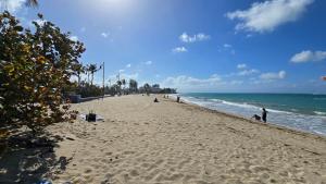 ein Strand mit Menschen im Sand und im Meer in der Unterkunft Oscar Building - Apto#1 in San Juan
