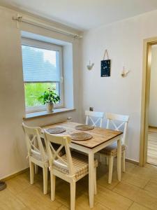 a dining room table with chairs and a window at Apartament 88 - Mrągowo Centrum, 2 sypialnie, taras in Mrągowo +5 photos