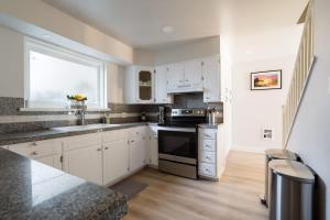 a kitchen with white cabinets and a sink and a window at Alphabet District - 2BR Retreat - Prime Locale in Portland