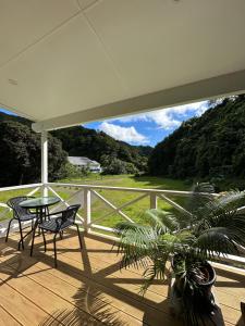 a patio with a table and chairs on a deck at The Valley Place in Rarotonga