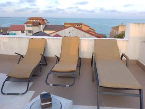 three chairs and a table on a balcony with the ocean at Samaya in Eforie Nord +6 photos