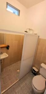 a bathroom with a toilet and a sink at Flow De Lupe in Brisas de Zicatela