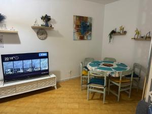a dining room with a table and a tv at Velazzura Marina- Duplex à Monastir in Monastir