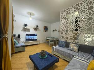 a living room with a couch and a tv at Velazzura Marina- Duplex à Monastir in Monastir