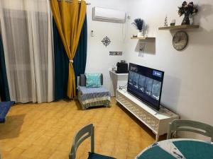 a living room with a flat screen tv and a chair at Velazzura Marina- Duplex à Monastir in Monastir +22 photos