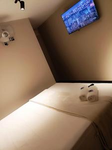 メデジンにあるHotel Golden 70の壁にテレビが付いたベッドのある寝室