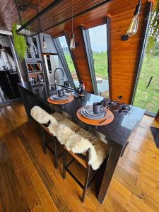 a kitchen with a dining table with furry cushioned chairs at Cabana Alecrim in Itanhandu