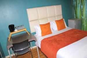 a bedroom with a bed and a desk with a chair at Cockpit Guest House Kempton Park Airport Getaway in Kempton Park