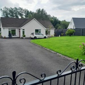 a house with a car parked in the driveway at Forest view in Ballycassidy