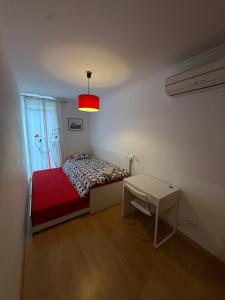 a small bedroom with a bed and a table at Urban Oasis in Mealhada +3 photos