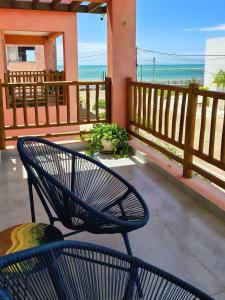una sedia seduta su un portico con vista sull'oceano di Casa Gostoso Mar - Apartamentos a São Miguel do Gostoso