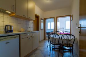 a kitchen with chairs and a table with a kitchen counter at Apartments OK in Lopar