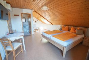 a bedroom with a bed and a table and chairs at Mettenberger Hof - Pension in Grafenhausen