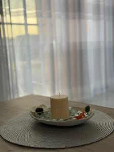 a candle on a plate on a table at FB Apartments in Ulcinj