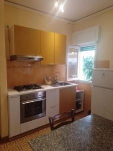 una cocina con fregadero y estufa horno superior en Casa della Costa - Porto Ercole Mare-, en Porto Ercole 1 foto más