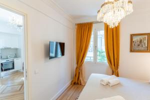 a white room with a table and a chandelier at Athens Plaka Acropolis Suites in Athens