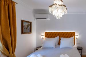 a bedroom with a bed with a chandelier at Athens Plaka Acropolis Suites in Athens
