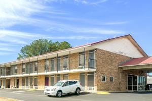 a car parked in front of a brick building at Regal Inn Guntersville By OYO Hwy 431 in Guntersville