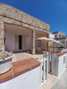 a patio with an umbrella and a table at Salento da amare in Marina di Mancaversa