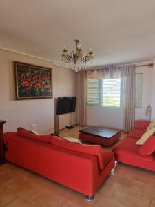 a living room with two red couches and a television at Roan's apartament in Golem