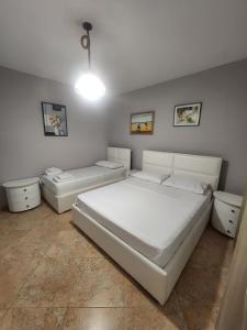 a white bedroom with two beds and two toilets at Roan's apartament in Golem