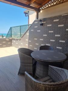 a table and chairs on a patio with the beach at Roan's apartament in Golem