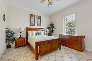 a bedroom with a bed and a dresser and a window at Escape Condominiums #2 in South Padre Island +8 photos