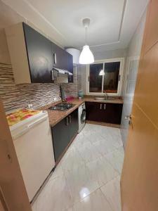 a kitchen with a sink and a dishwasher at Appartement Cosy & Calme avec Piscine, Tamaris Dar Bouazza in Tamaris