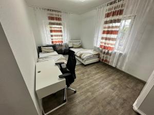 纽伦堡Double room and shared bathroom的有两张床、一张桌子和一把椅子的房间