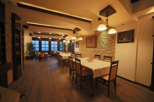 a dining room with tables and chairs and a brick wall at Villa od Alula in Vevčani