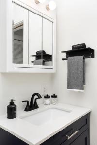 a white kitchen with a sink and a mirror at Little 5 Condo King Beds Ping-pong Garage in Bloomington