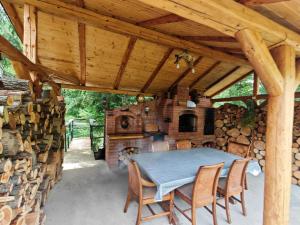 a patio with a table and chairs under a wooden roof at Ryan's Cabin in Huisurez
