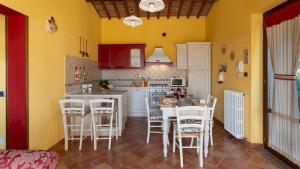 Una cocina con una mesa y sillas en una habitación. en Villa Peruccio Gioiello in Volterra, en Volterra