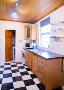 a kitchen with a black and white checkered floor at Modern, Spacious Home Ideal for Work Teams and Groups in Luton +38 photos