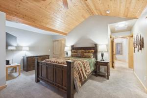 a bedroom with a large bed and a wooden ceiling at Whispering Pines in Whitefish +40 photos