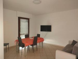 a dining room with a table with chairs and a television at Appartamento Sutri con posto auto riservato in Sutri