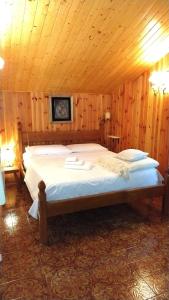 a bedroom with a large bed in a wooden room at Appartamento Volturina in Fiumalbo