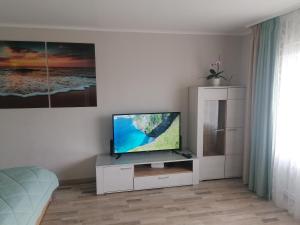 a living room with a flat screen tv on a white cabinet at Jurmala Kauguri in Jūrmala