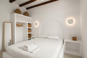 a white bedroom with a white bed with towels on it at Kardiani Blue Serenity in Kardhianí