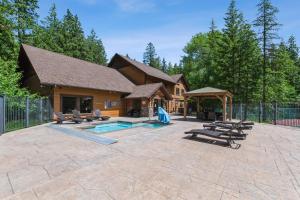 a house with a swimming pool and some chairs at Cedar Creek Cabin in Whitefish