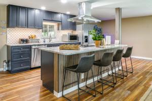 a kitchen with a large island with bar stools at Lakefront Home with Hot Tub and Dock in Orlando! in Orlando