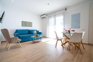 a living room with a blue couch and a table at Art 80 - A2 in Artemida