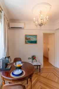 a dining room with a table and a chandelier at Athens Plaka Acropolis Suites in Athens