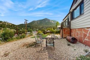 een terras met stoelen en een gebouw met bergen op de achtergrond bij Courtney Cottage - Permit #3479 in Estes Park